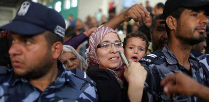 Una mujer con su hijo pide un visado en Gaza para cruzar a Egipto.