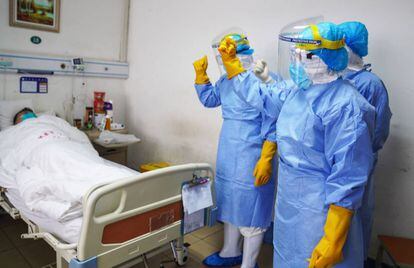 Miembros del personal médico animan a un paciente infectado por el coronavirus en una sala de aislamiento en un hospital de Zouping, en la provincia china de Shandong, el pasado martes.
