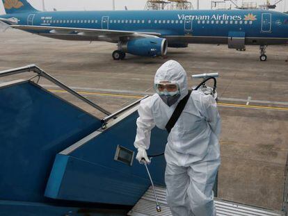 Trabajadores desinfectan un avión en Hanoi, Vietnam. 