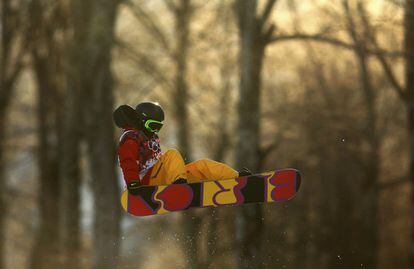 La china Cai Xuetong realiza un salto durante la prueba de snowboard
