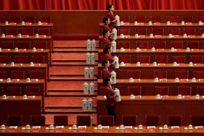 Azafatas preparan las mesas donde se sentarán los más de 2.200 delegados presentes en la ceremonia de apertura del Congreso Nacional del Partido Comunista Chino, en Pekín, el 18 de octubre de 2017.