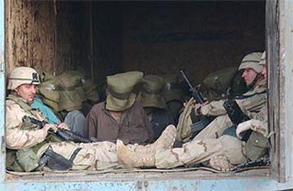 <i> marines</i> estadounidenses vigilan a varios prisioneros afganos en Kandahar.