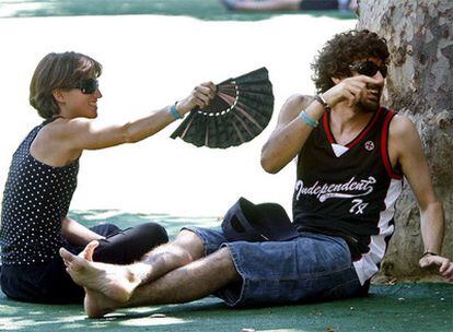 Dos asistentes se protegen del calor en un área habilitada en festival Sónar 2008.