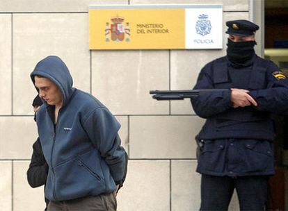 Uno de los detenidos ayer por la policía, esposado junto a la comisaría de San Sebastián.