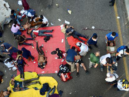 SENSITIVE MATERIAL. THIS IMAGE MAY OFFEND OR DISTURB Paramedics help people injured at the site of a trailer accident that left at least 49 people dead, most of them migrants from Central America, in Tuxtla Gutierrez, in Chiapas state, Mexico December 9, 2021. REUTERS/Jacob Garcia TPX IMAGES OF THE DAY