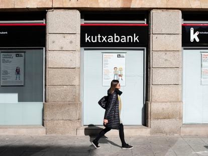 Una mujer camina por delante de una sucursal de Kutxabank, en Salamanca.