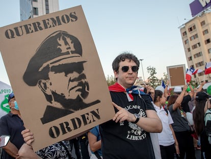 Un hombre sostiene un cartel con el rostro de Augusto Pinochet en una protesta a favor de la policía el 6 de abril 2023 en Santiago, Chile.