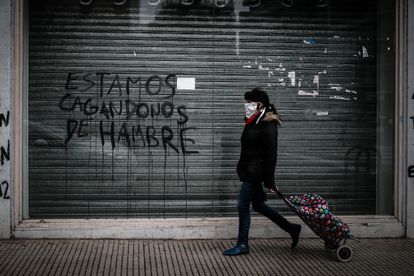 Una persona camina delante de un comercio cerrado por la crisis económica, en julio pasado en Buenos Aires.