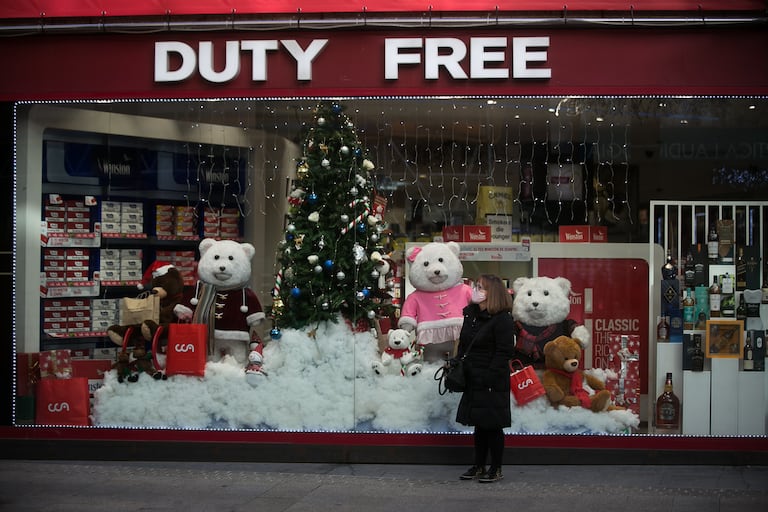Una mujer espera junto al escaparate de un Duty Free de Andorra la Vella.