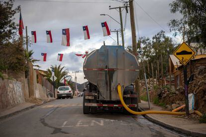 Un camión aljibes abastece de agua a una casa en un barrio de Petorca.