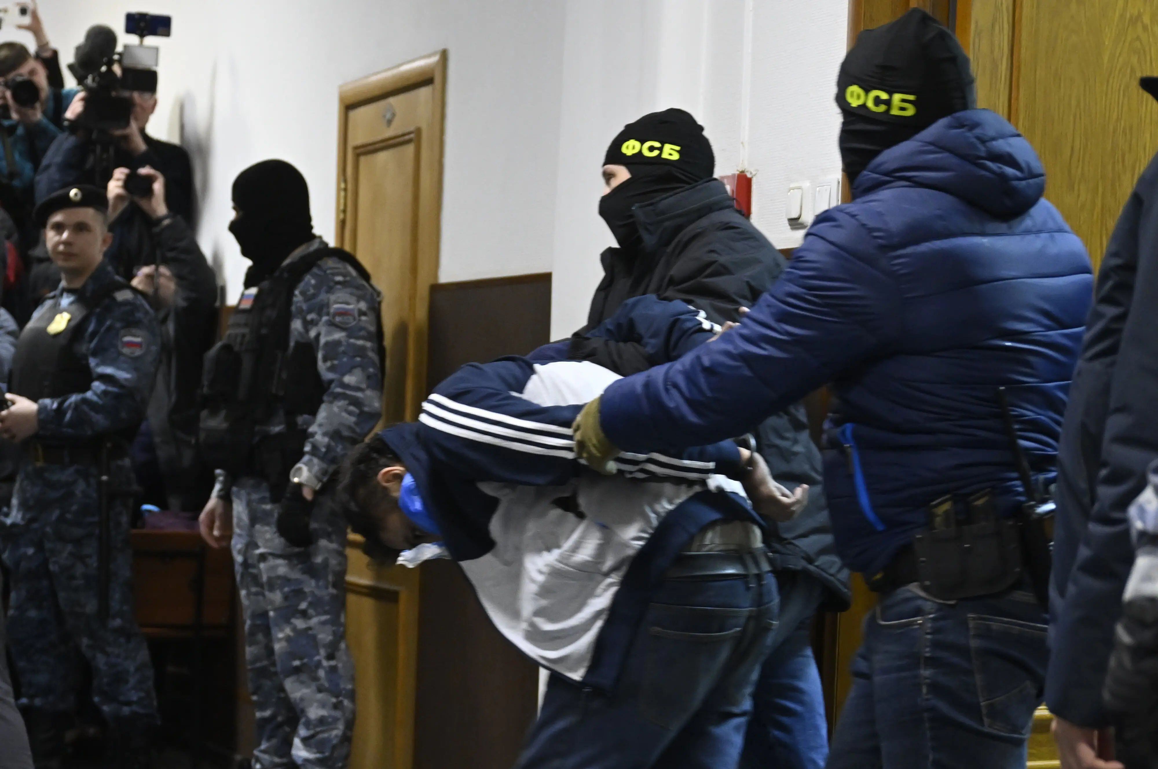 Agentes del Servicio Federal de Seguridad de Rusia con uno de los sospechosos del atentado de Moscú, en los juzgados de la capital rusa.