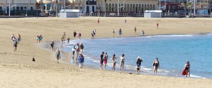 Varias personas mayores pasean por la orilla de la playa de Las Canteras este sábado, día que ha amanecido con cielos despejados y temperaturas veraniegas.