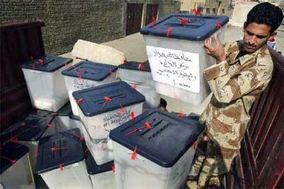 Un miembro de las fuerzas de seguridad iraquíes colabora en el traslado de urnas a un centro de recuento ayer en Bagdad.