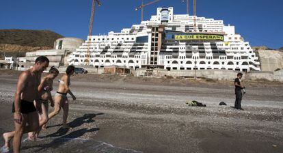 Ba&ntilde;istas pasean ante el hotel El Algarrobico.