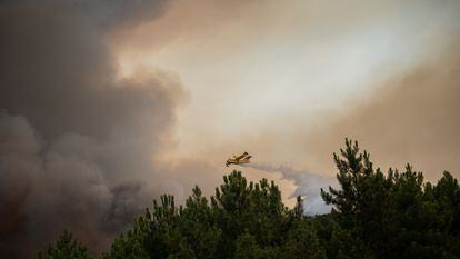 Una avioneta suelta la carga de agua sobre las llamas que se han avivado desde primera hora de la mañana de este martes en Casares de las Hurdes (Cáceres).