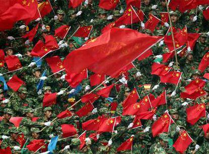 Soldados chinos enarbolan banderas de su país con ocasión del paso de la antorcha olímpica por Mianyang, el pasado lunes.