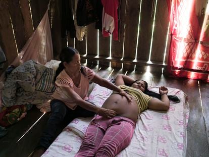 Clemencia Benítez, partera Tikuna de la comunidad de Nazaret, atiende a su nuera embarazada.