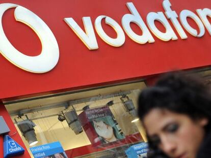 Un transe&uacute;nte camina frente a una tienda de Vodafone. EFE/Archivo