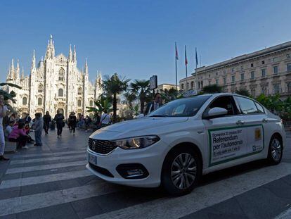 Un taxi lleva publicidad sobre el refer&eacute;ndum lombardo en la plaza del Duomo en Mil&aacute;n.