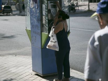 Una mujer usa una cabina telefónica en Madrid.