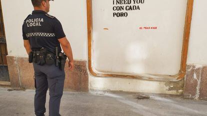 El agente que ha dado con la identidad de la grafitera, junto a una de las pintadas ya borradas de las calles de El Puerto.