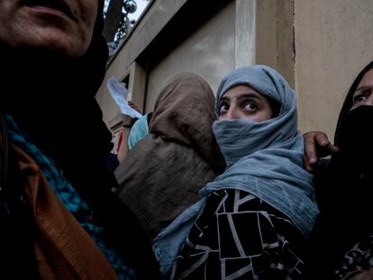 Una mujer afgana y su familia trataban de entrar en agosto de 2021 en un hotel de Kabul, desde donde partían autobuses para el aeropuerto, tras la toma de poder por los talibanes.