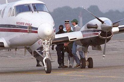 Policías franceses trasladan al ex concejal de Batasuna Robert Arrambide hasta un avión en el aeropuerto de Biarritz para su traslado a París.