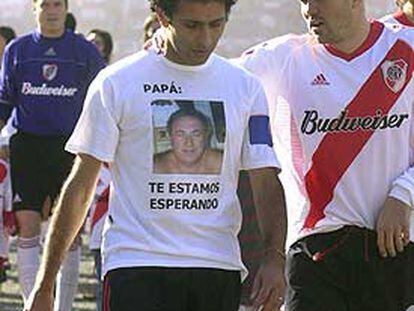 Astrada, con una camiseta alusiva al secuestro de su padre, junto a Coudet, el domingo 6, día de su retirada.