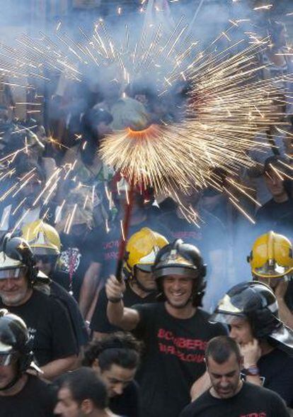 Un grupo de bomberos con fuegos artificiales, ayer en la Via Laietana de Barcelona