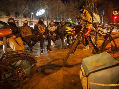 Un grup de 'riders' esperen les comandes al carrer, a Barcelona.