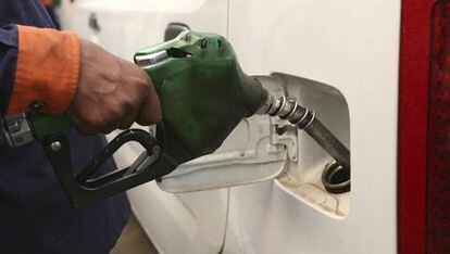 Un operario dispensa gasolina 95 en una gasolinera.