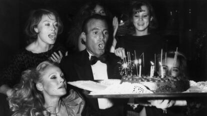 El cantante Julio Iglesias apaga las velas de su tarta de cumpleaños en 1983. La actriz suiza Ursula Andress (abajo a la izquierda) estaba entre los invitados.