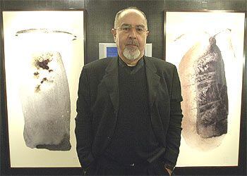 Bigas Luna, entre dos pinturas digitales de su exposición <i>Semillas</i> en la Fnac de Madrid.