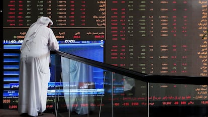 A Kuwaiti trader looks at a local stock exchange listing panel, in a file image.
