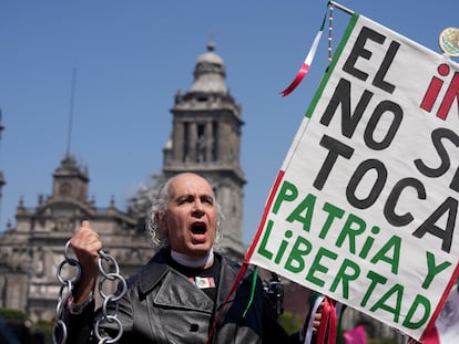 Un manifestante disfrazado del padre de la patria, Miguel Hidalgo, sostiene un cartel con la frase "El INE no se toca. Patria y libertad", durante la protesta de este domigno en Ciudad de México.