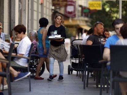 Una joven camarera atiende una terraza en la zona centro de Madrid.