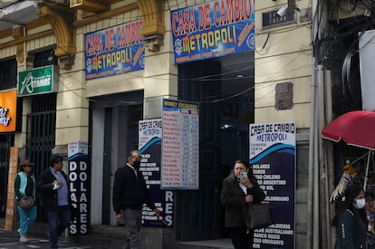 Ciudadanos pasan frente a locales de venta de dólares en La Paz.