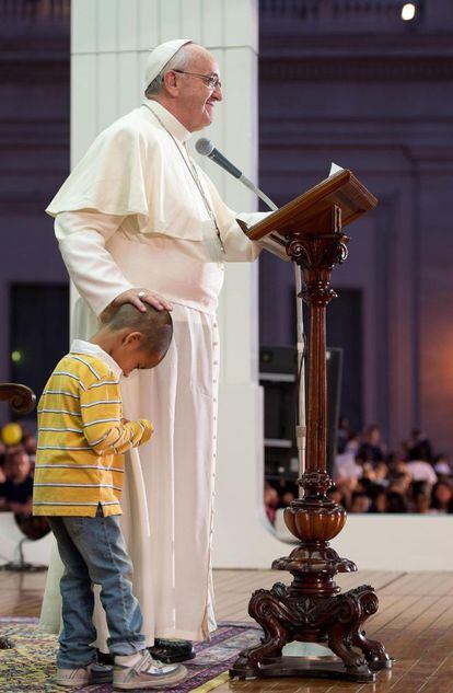 El Papa Francisco junto al niño que se subió al escenario para abrazarle durante su intervención en la Fiesta de la Familia que se celebró el 26 de octubre de 2013, en la Basílica de San Pedro.