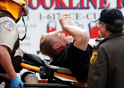 Un hombre grita mientras es evacuado en una camilla por el personal de emergencia.