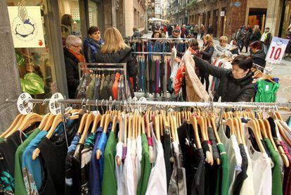 Una mujer observa las ofertas de uno de los puestos del mercado de gangas del Casco Viejo de Bilbao.