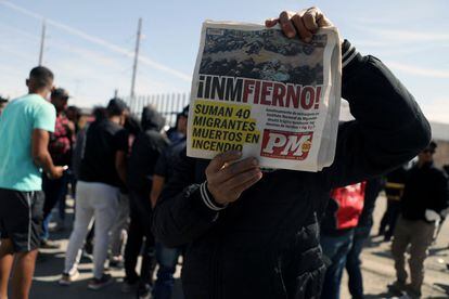Una persona muestra la portada de un diario local con la noticia del incendio en Ciudad Juárez.