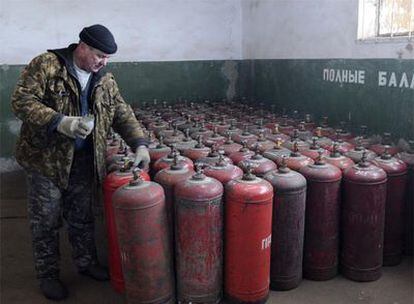 Un trabajador ucranio supervisa bombonas de gas en una estación de Brovary.