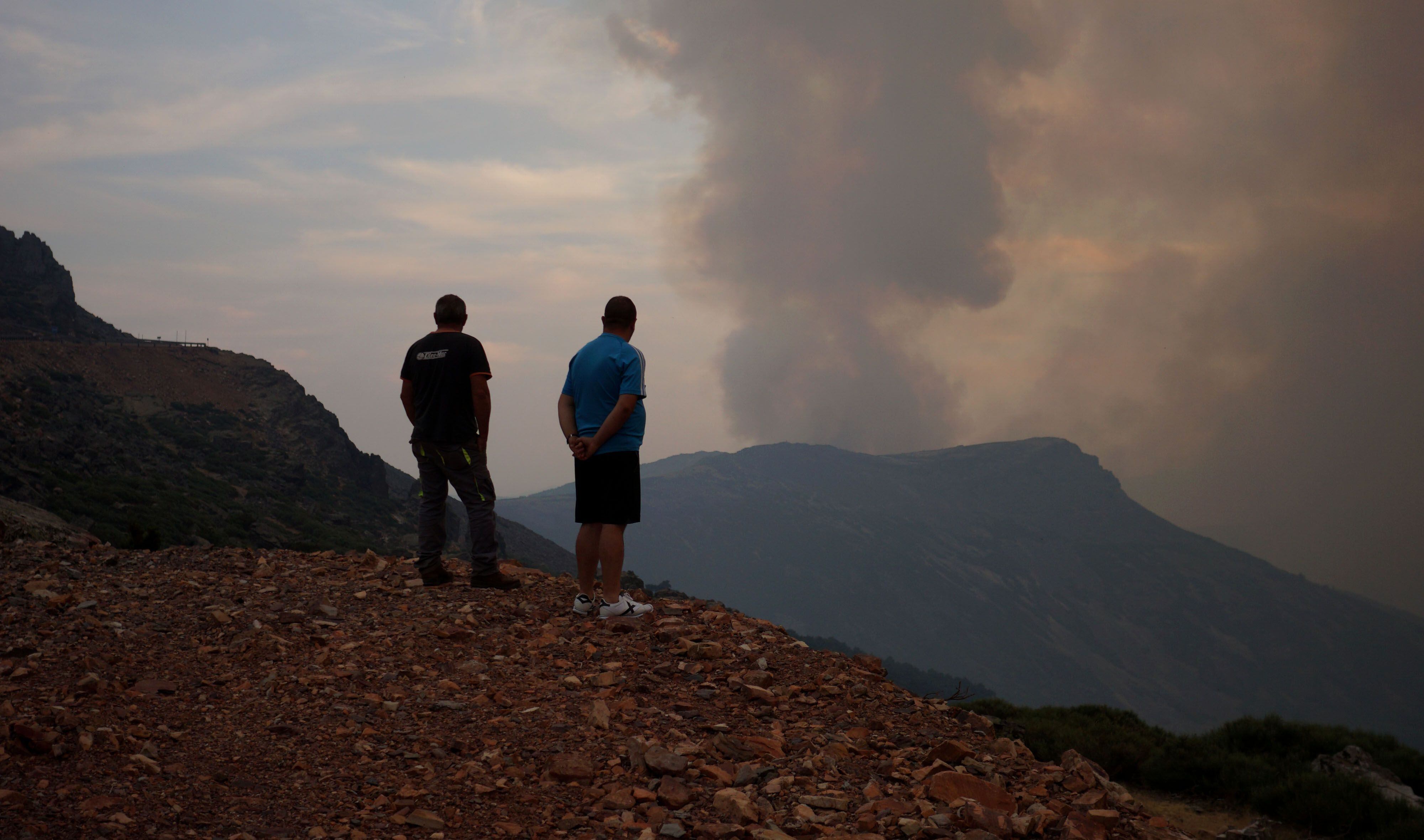 Dos hombres observan el incendio en el mirador de la Peña de Francia mientras uno de ellos recuerda el fuego que arrasó la zona hace cuarenta años.