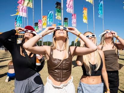 Mujeres observan el eclipse solar del 14 de octubre de 2023 en un festival de música en Austin.
