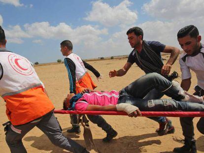 Un palestino herido por las protestas en la frontera de Gaza es evacuado por sanitarios.