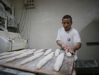 Un trabajador prepara barras de pan en el obrador de una panadería en Lugo.