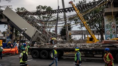 Trabajadores laboran en la remoción de escombros y estructuras tras el accidente de la Línea 12 del metro en Ciudad de México.