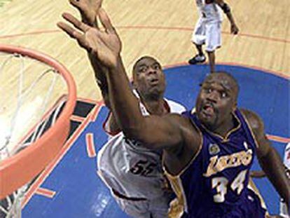 Shaquille O'Neal y Dikembe Mutombo luchan por un rebote en el tercer partido de la final.