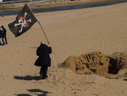 Una persona pasaba el domingo junto a una escultura de arena en la playa de San Lorenzo, en Gijón.