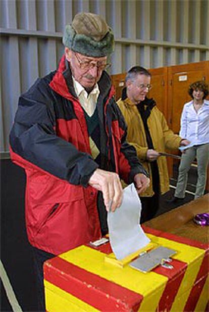 Un suizo deposita su voto esta mañana.